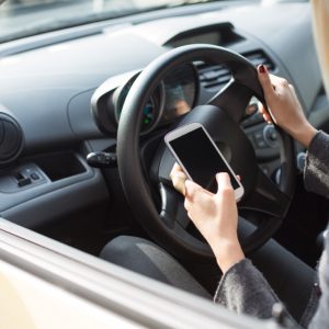 Woman sending text messages while driving.