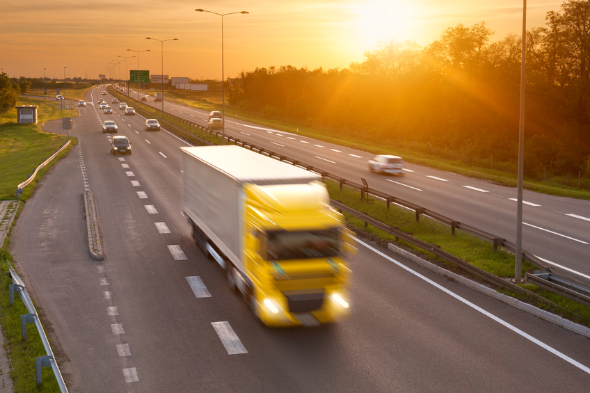 Yellow truck in the rush hour on the highway at dusk