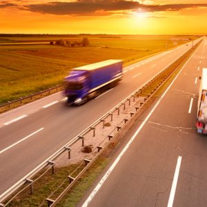 Blue and white truck in motion blur on the highway at sunset