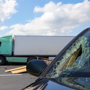 View of truck in an accident with car, cloudy sky