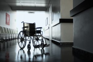 Standard manual wheelchair standing in empty hospital corridor