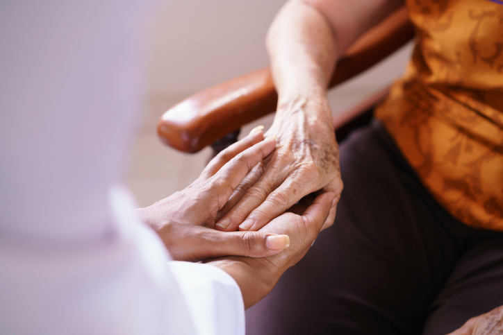 mujer mayor en una residencia de ancianos con la mano apretada