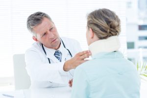 Doctor checking neck brace of his patient in medical office