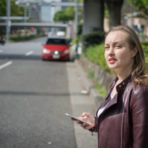 woman waiting for lyft or uber rideshare