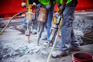 Construction workers operating jackhammers