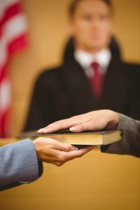 Witness swearing on the bible telling the truth in the court room