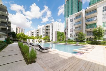 A pool with chairs overlooking apartment buildings