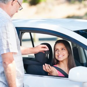 Student driver passes exam and instructor hands her car keys