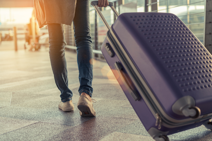 Traveler with suitcase in airport concept.Young girl walking with carrying luggage and passenger for tour travel booking ticket flight at international vacation time in holiday rest and relaxation.