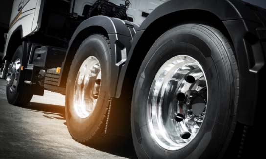 Image of a semi truck focused on the wheels.