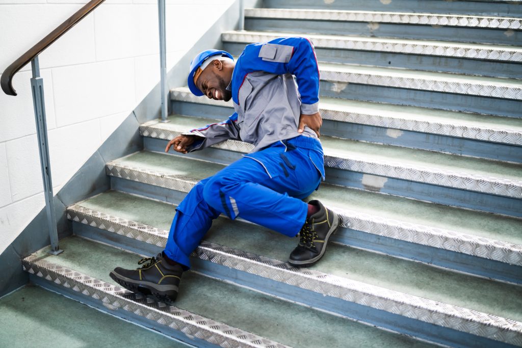 Male Worker Lying On Staircase After Slip And Fall Accident