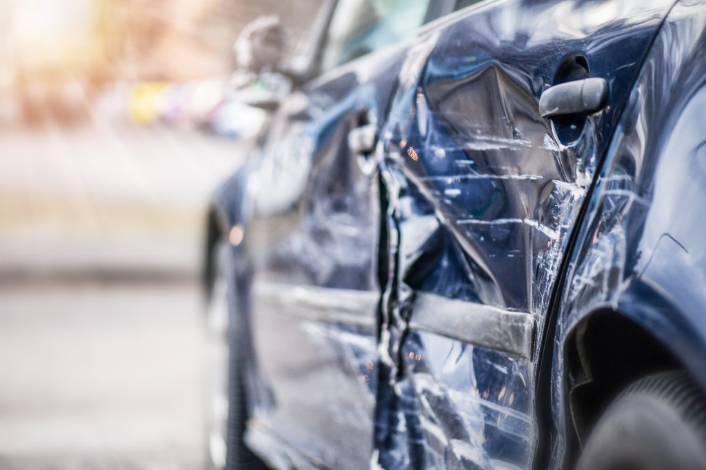 Damaged side of a blue car after an accident