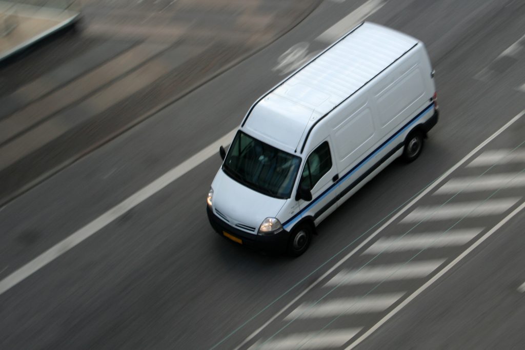 a white delivery van on the road