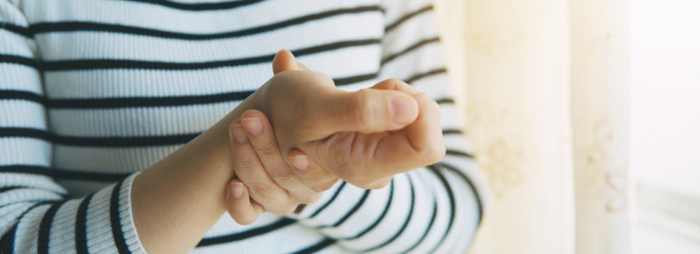 Woman massaging her injured hand and wrist