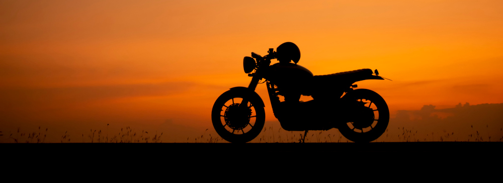 Silhouette of motorcycle at sunset.